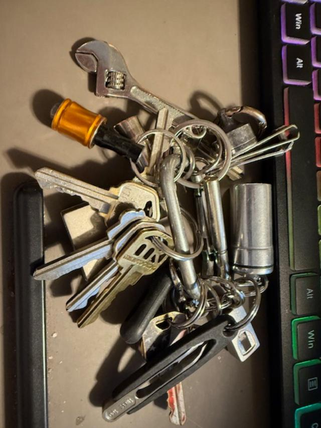 A real, heavily loaded keyring with keys, mini tools, a wrench and accessories